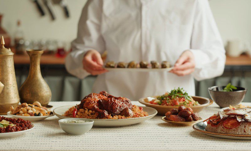 A chef proudly presents a beautifully arranged plate of food