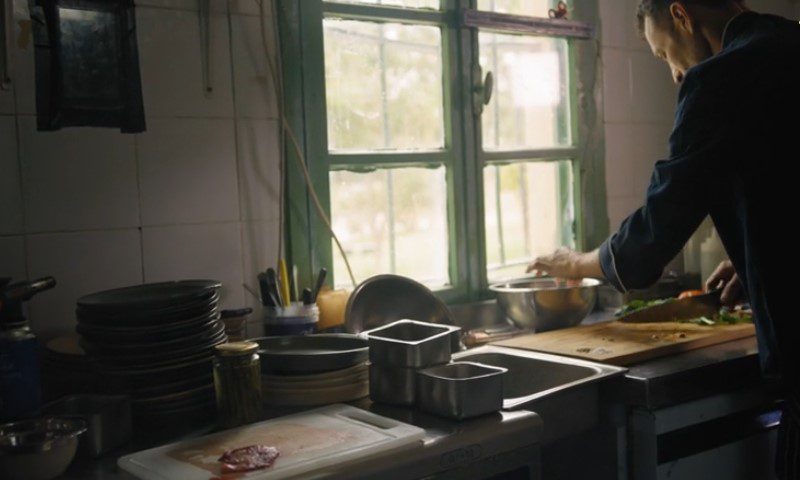 A man is preparing food in a kitchen
